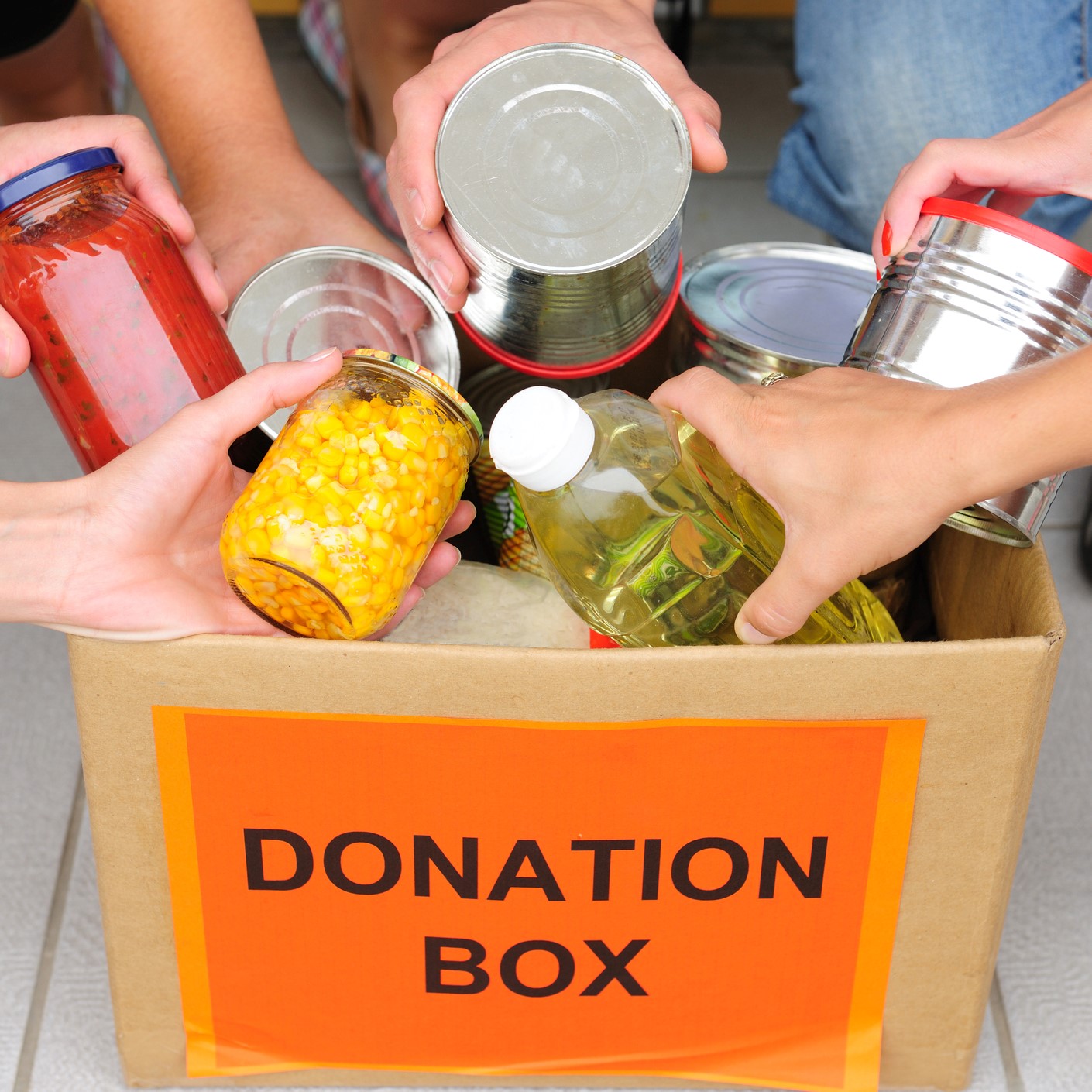 People putting food in a donation box